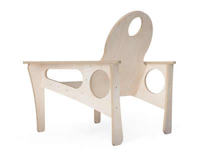 A minimalist, light natural wood chair with unique circular cutouts in the backrest, armrests, and base, shown on a solid white background.