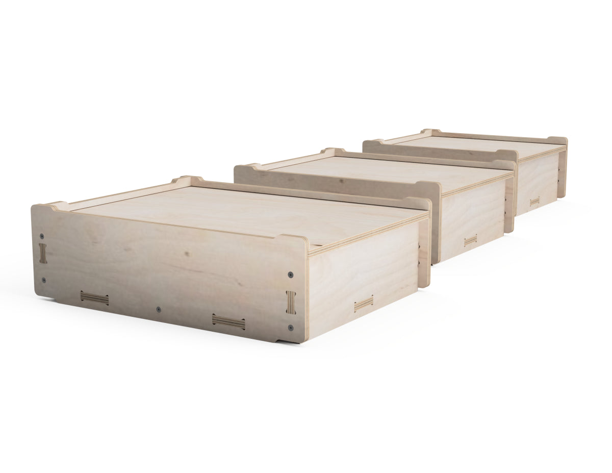 Three light natural wood storage boxes arranged in a diagonal row on a clean white background.